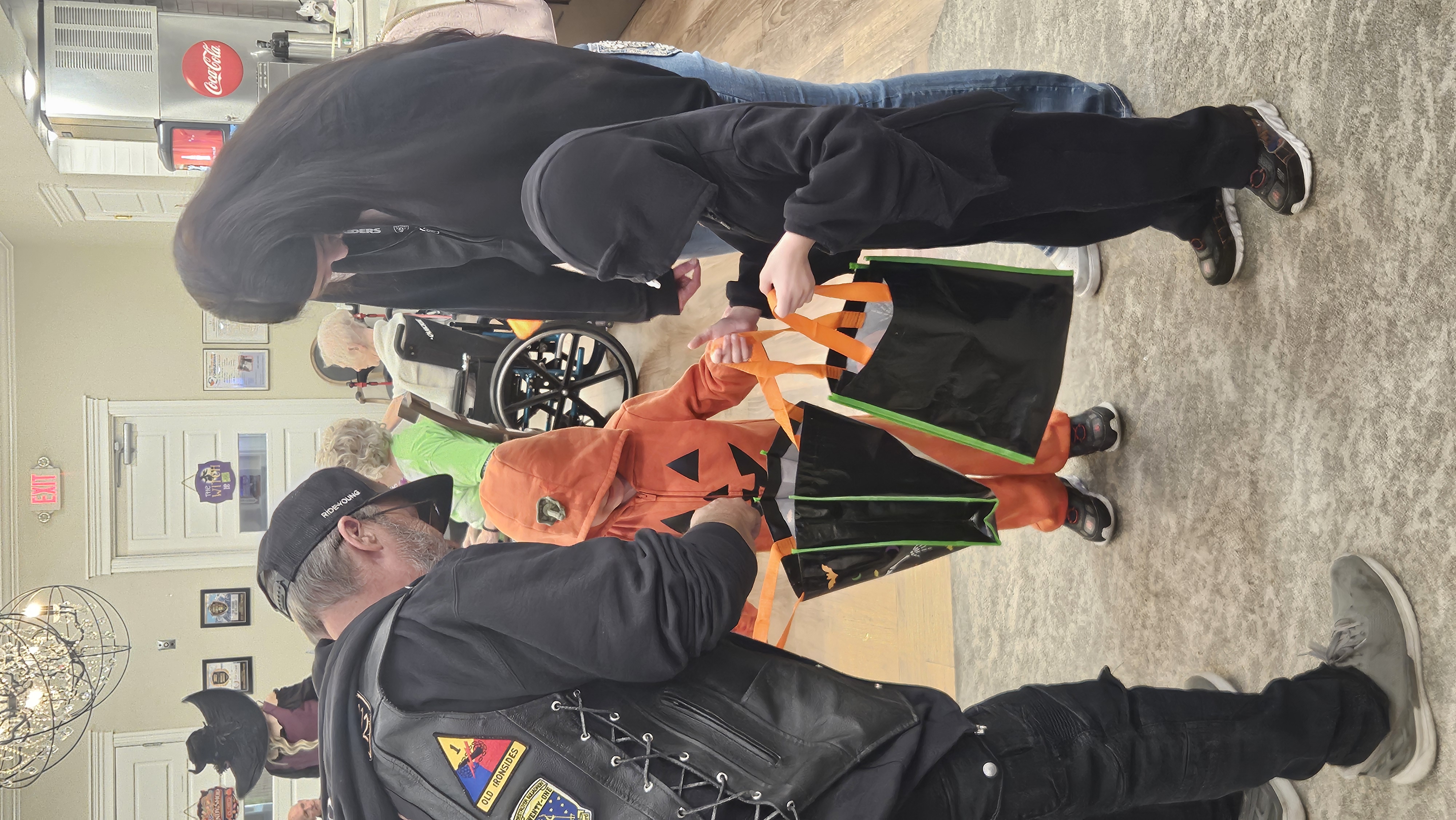 A Rider giving candy to children wearing Halloween costumes