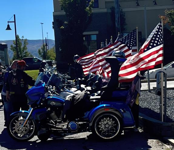 A blue motorcycle and American flags at a gathering of riders