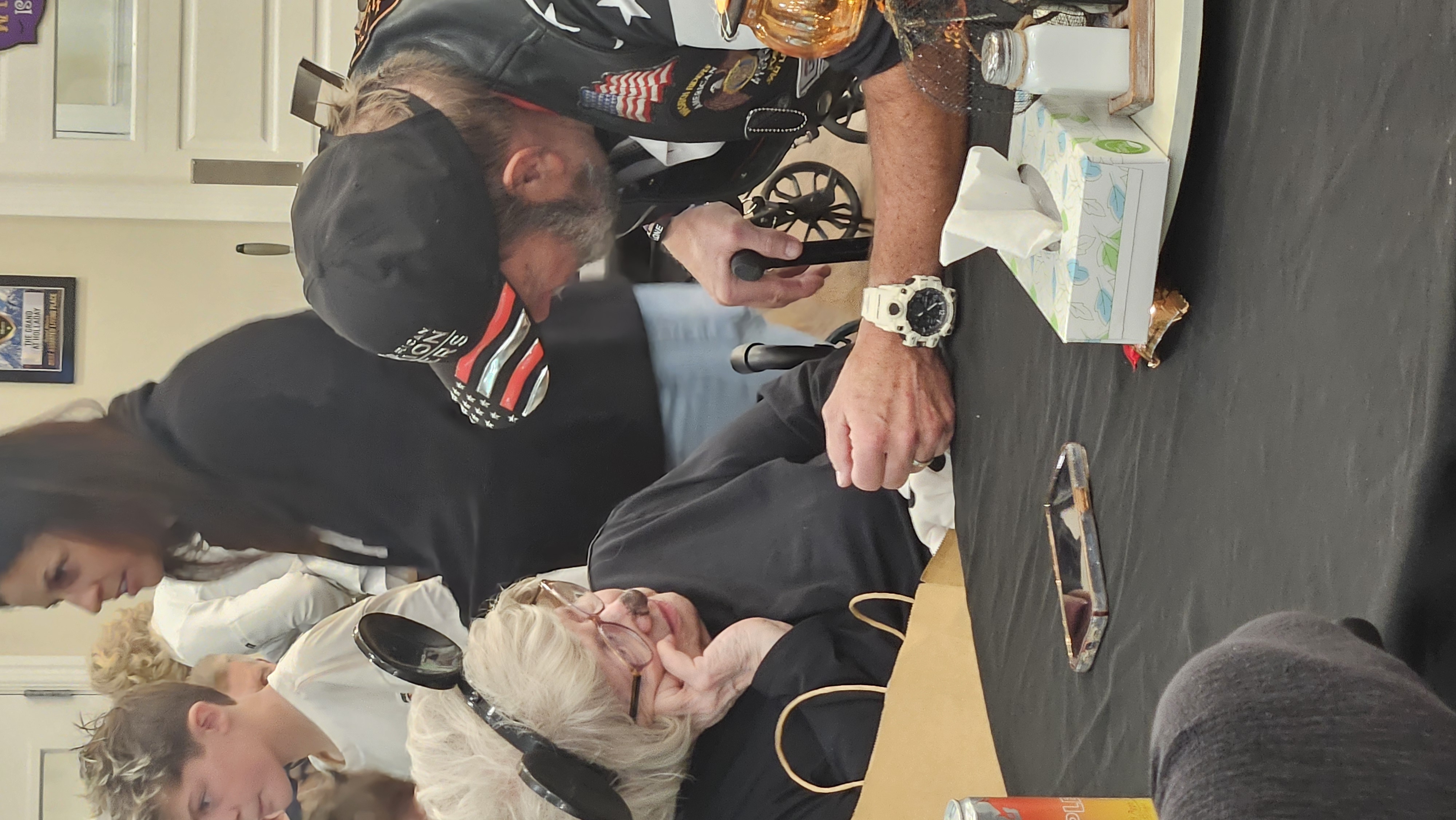 A Legion Rider leaning in to talk with a senior during the community visit